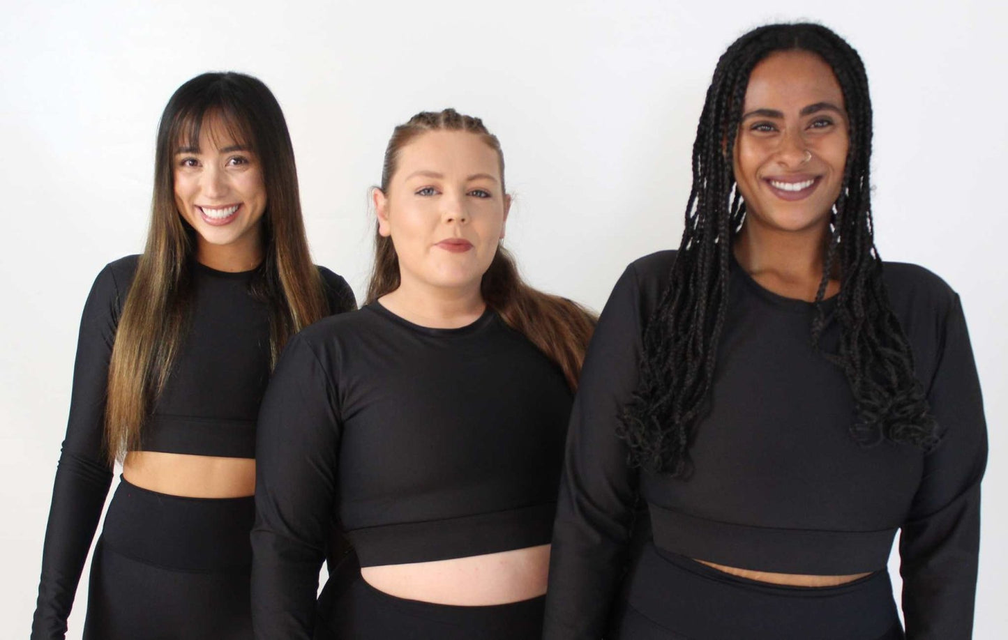 three girls standing and smiling. wearing long sleeve black activewear top from vocus vit. Vocus vit is a sustainable women's activewear brand that uses recycled materials and ethical manufacturing. Based in Northern Ireland. Shipping worldwide.Sizes XS (8) TO XXL (18).