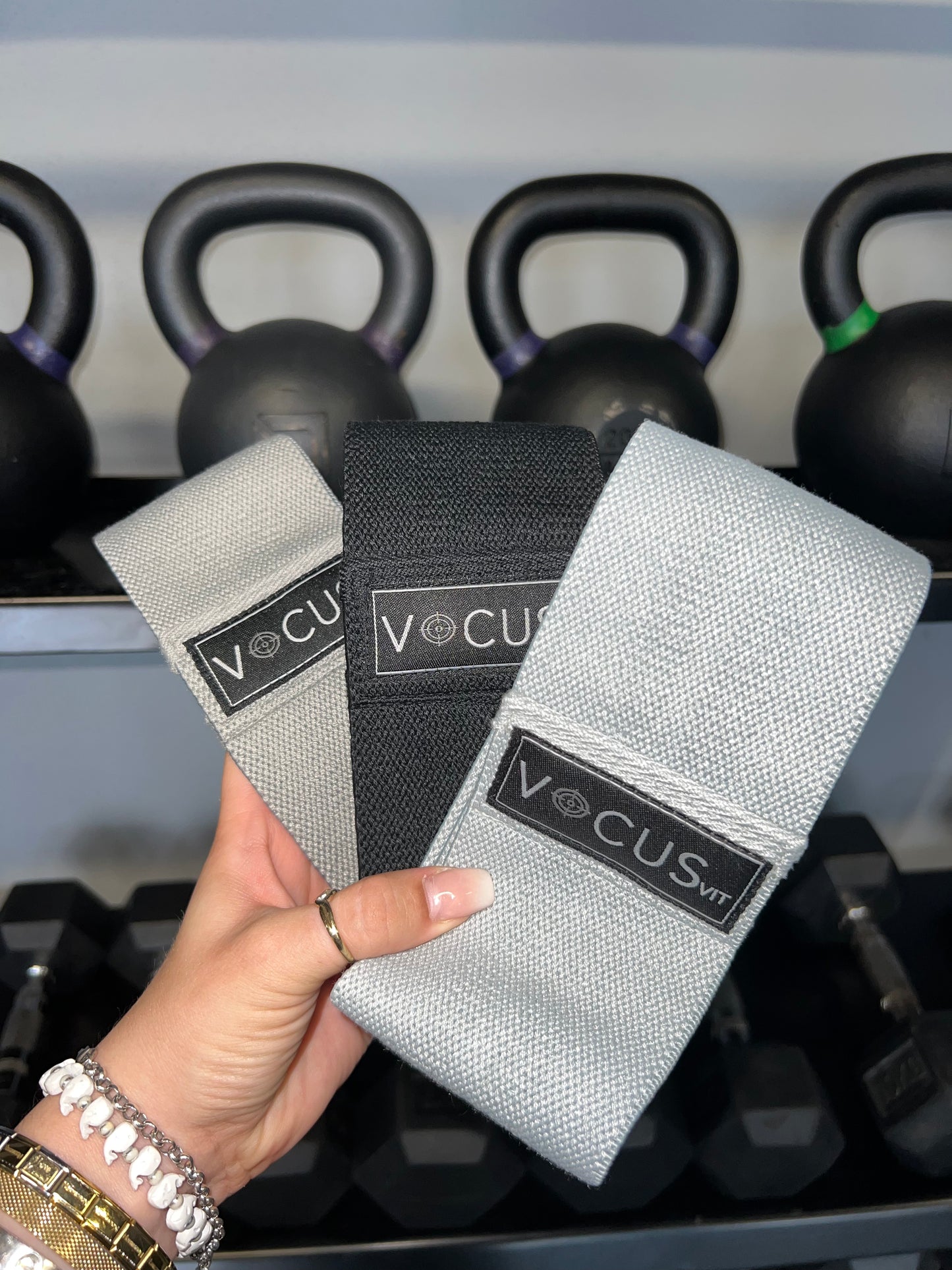 Hand holding 3 resistance bands. Light, medium and heavy resistance. Vocus Vit logo on them. Vocus vit is a sustainable women's activewear brand that uses recycled materials and ethical manufacturing. Based in Northern Ireland. Shipping worldwide.