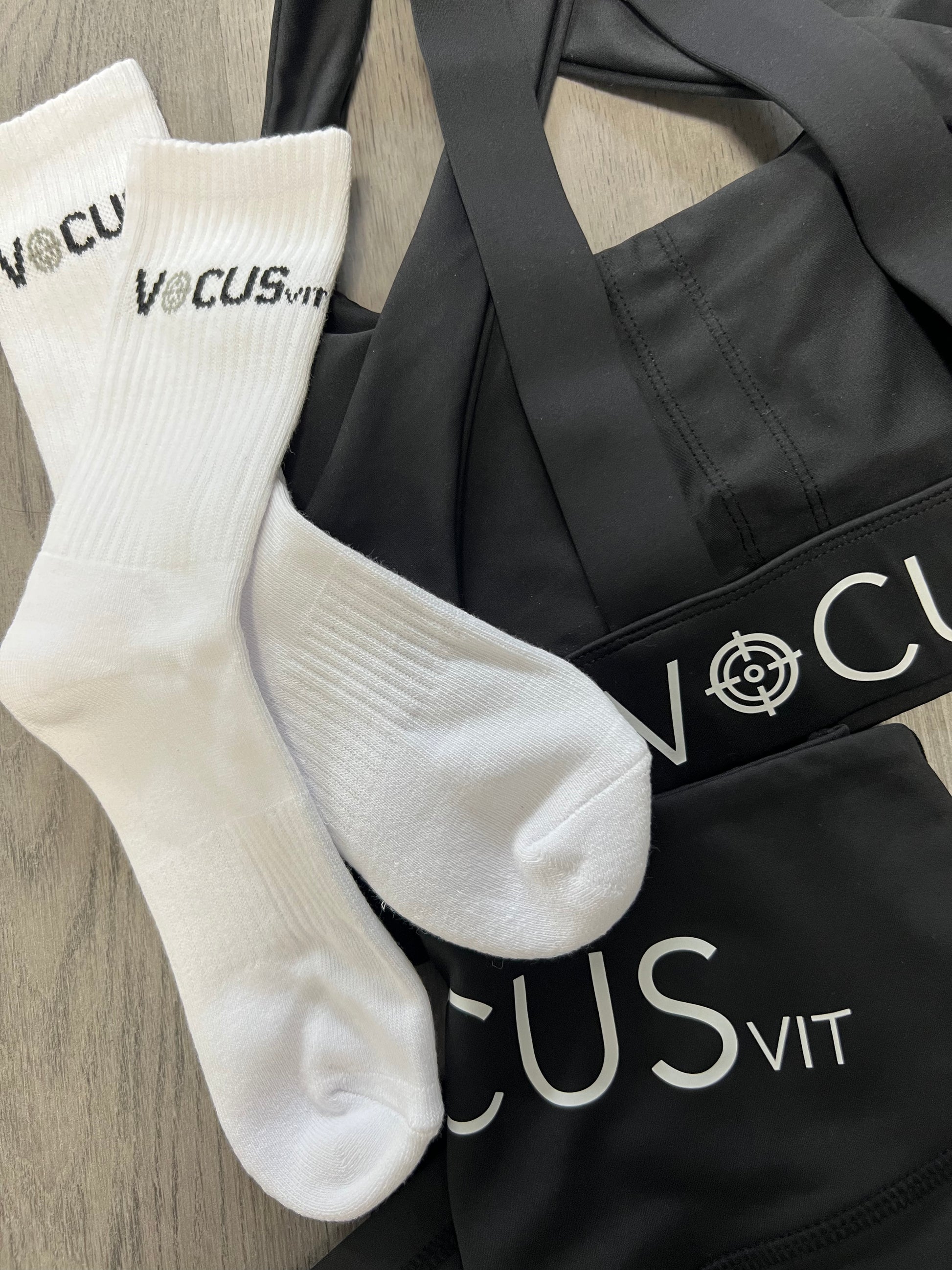 Crew socks and black sports bra and shorts. Laid out on a flat surface. Vocus vit is a sustainable women's activewear brand that uses recycled materials and ethical manufacturing. Based in Northern Ireland. Shipping worldwide.