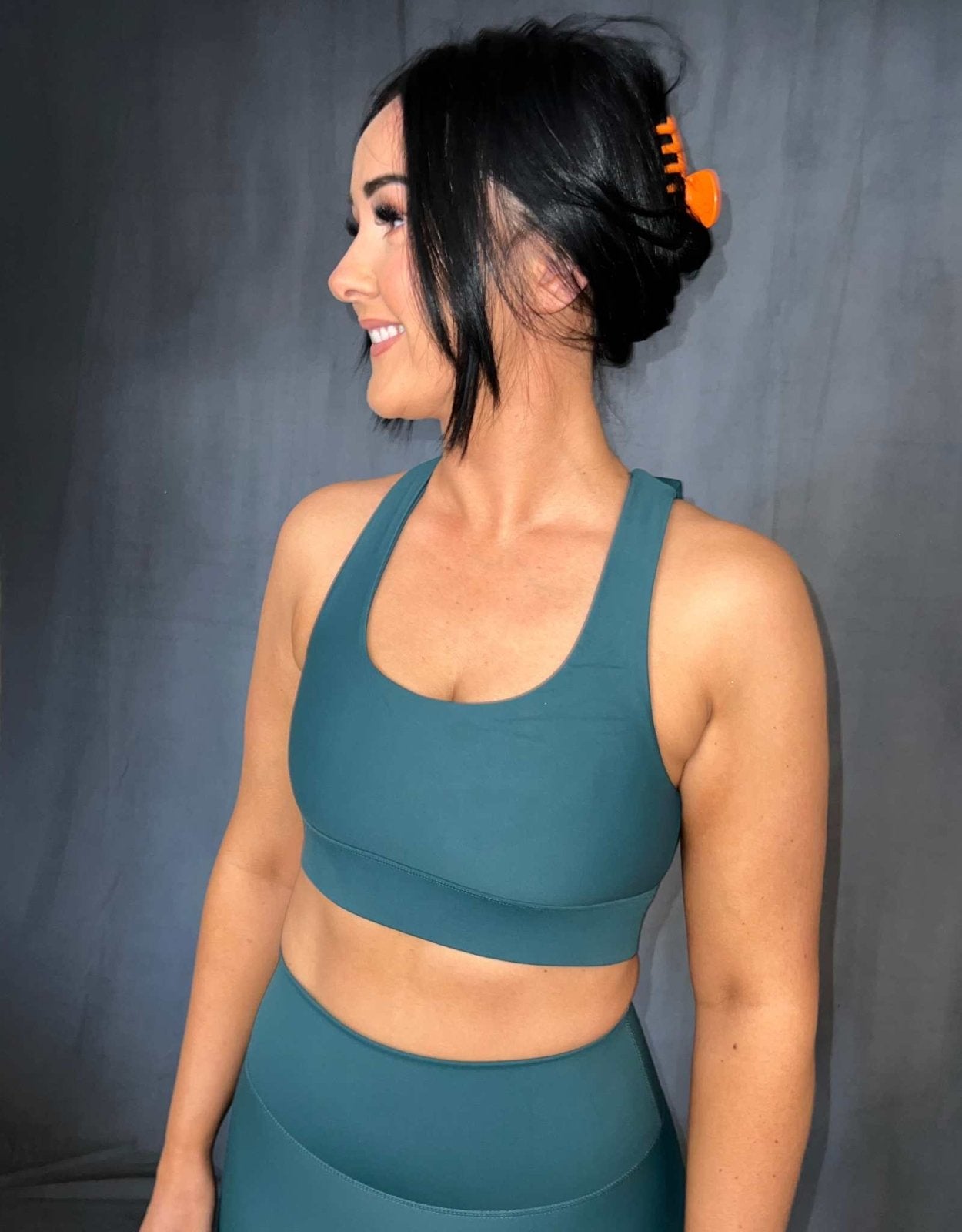 Girl standing wearing green activewear from vocus vit. she has a sports bra and shorts on. Vocus vit is a sustainable women's activewear brand that uses recycled materials and ethical manufacturing. Based in Northern Ireland. Shipping worldwide.Sizes XS (8) TO XXL (18).