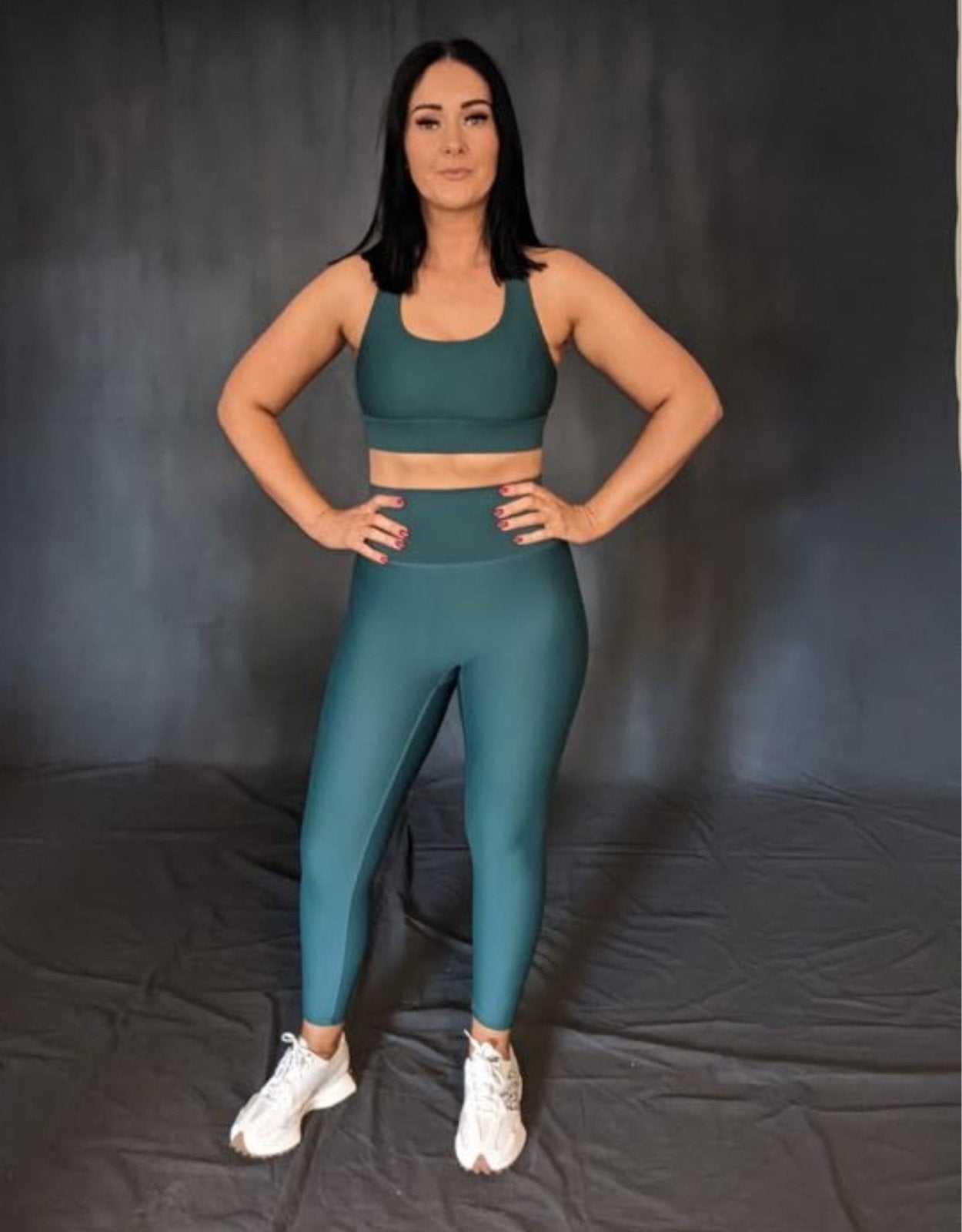 girl standing with hands on her hips. she is wearing green (evergreen) leggings and sports bra from vocus vit. Vocus vit is a sustainable women's activewear brand that uses recycled materials and ethical manufacturing. Based in Northern Ireland. Shipping worldwide.Sizes XS (8) TO XXL (18).