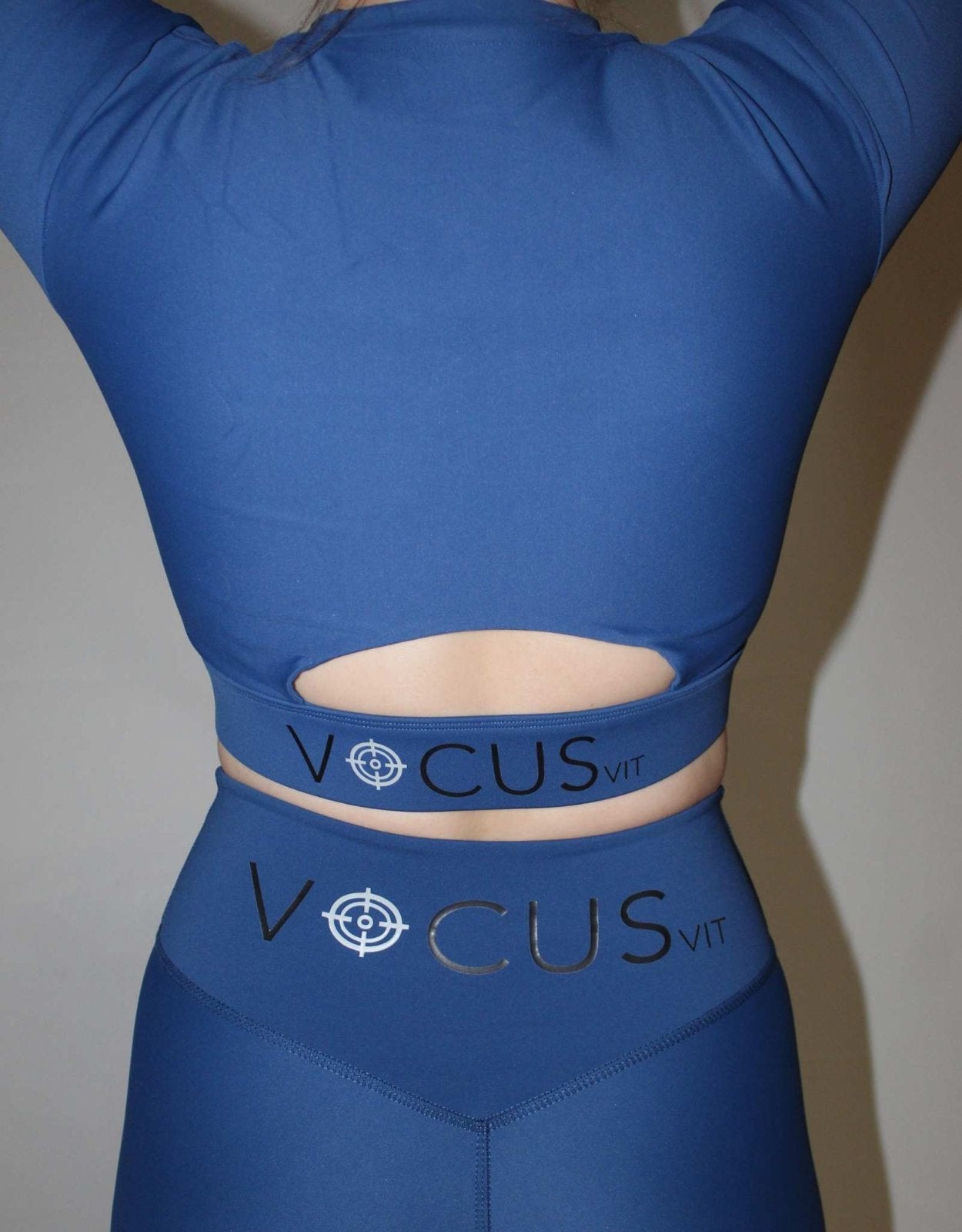 Back of the long sleeve top from Vocus vit in blue. arch cut out in top and big logo at back. Vocus vit is a sustainable women's activewear brand that uses recycled materials and ethical manufacturing. Based in Northern Ireland. Shipping worldwide.Sizes XS (8) TO XXL (18).